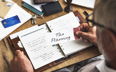business owner looking at note that reads tax planning